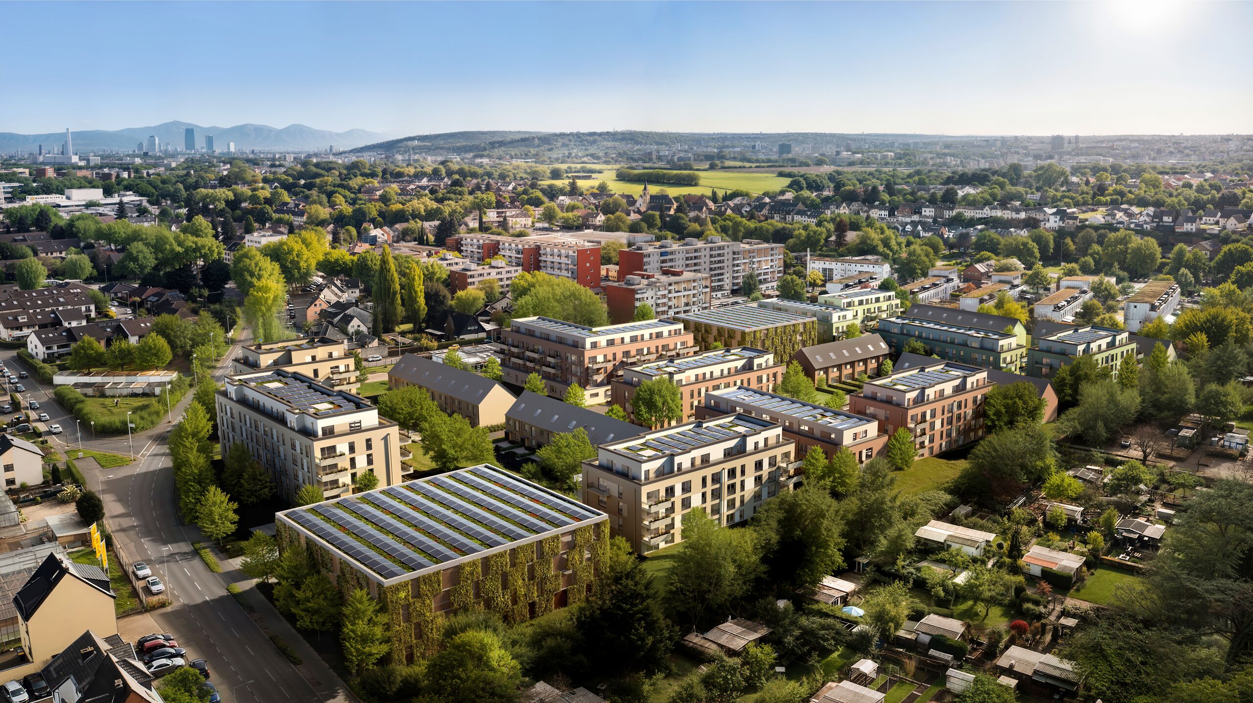 Luftbild-Visualisierung des GROOTE Quartiers in Bonn-Dransdorf im Sommer: neue Wohnhäuser mit begrünten Fassaden und Photovoltaik auf den Dächern, umgeben von Bäumen und Gärten.